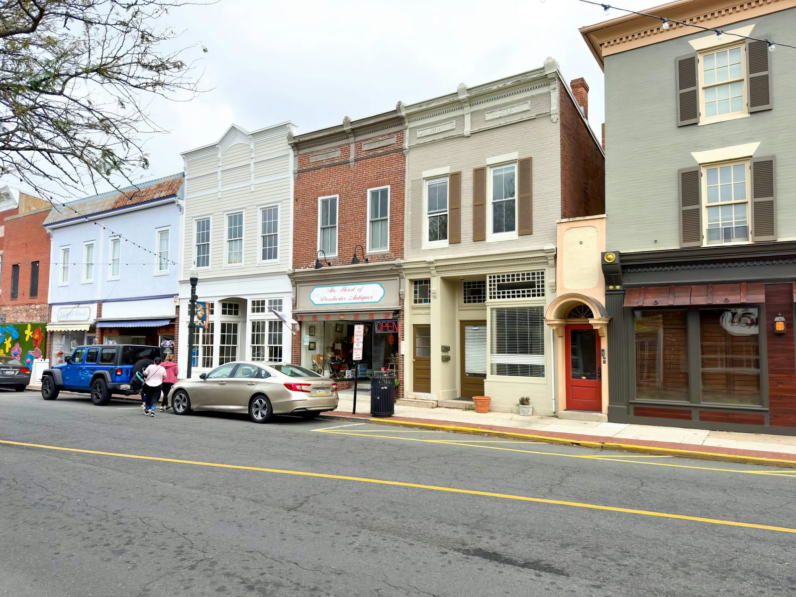 A row of restored two-story brick and clapboard storefronts along a small-town main street.