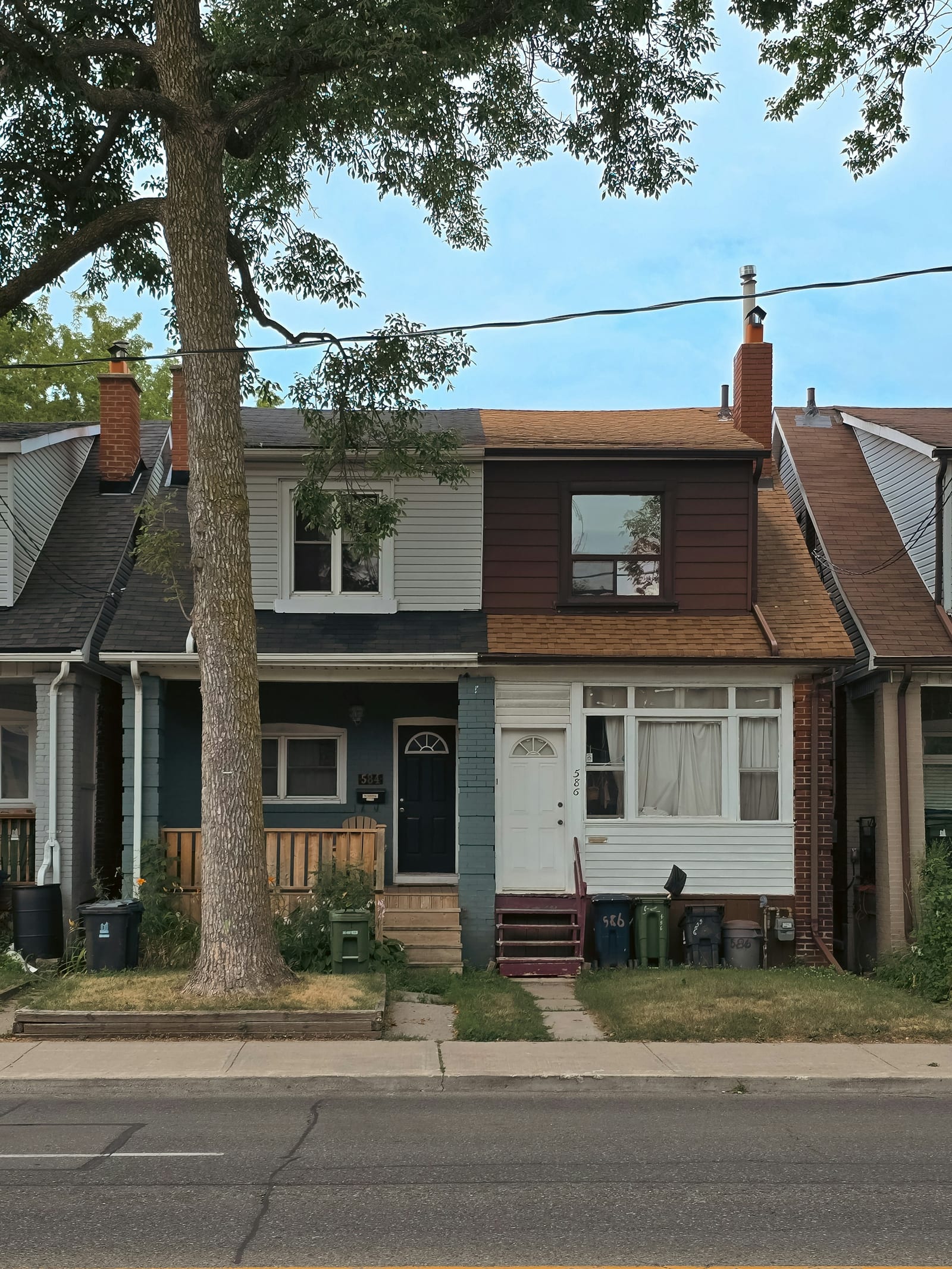 Two older attached houses side by side on a residential street.